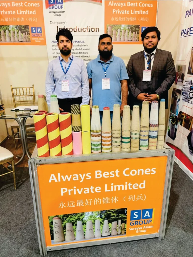 Another angle of the 'Always Best Cones' booth with three men posing in front of a variety of colorful paper cones.